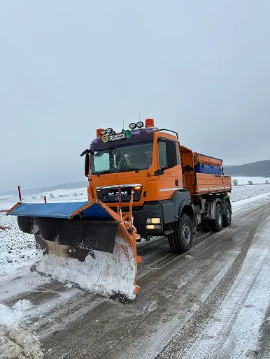 MAN LKW mit Schneepflug räumt Landstraße